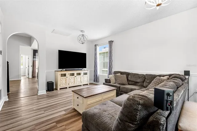 a kitchen with stainless steel appliances granite countertop a refrigerator a stove and white cabinets with wooden floor