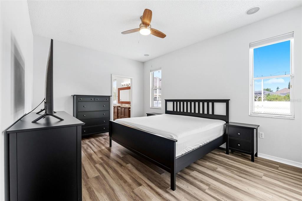 10443 Peppergrass Court Trinity, FL 34655 - Photo 24 of 62 a spacious bedroom with a bed and a flat screen tv