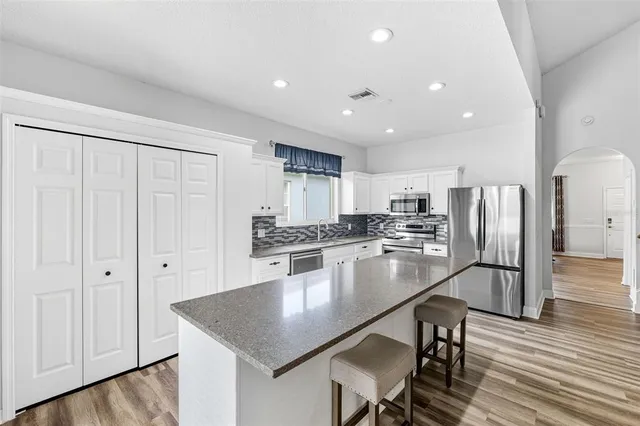a kitchen with stainless steel appliances granite countertop a stove and a sink