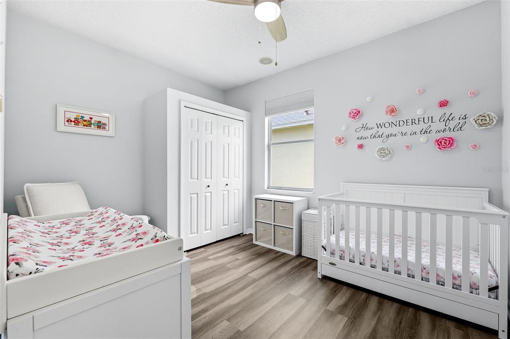 10443 Peppergrass Court Trinity, FL 34655 - Photo 39 of 62 a bedroom with a bed and wooden floor