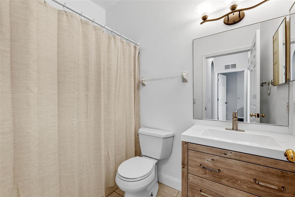 10443 Peppergrass Court Trinity, FL 34655 - Photo 41 of 62 a bathroom with a sink a toilet and shower curtain