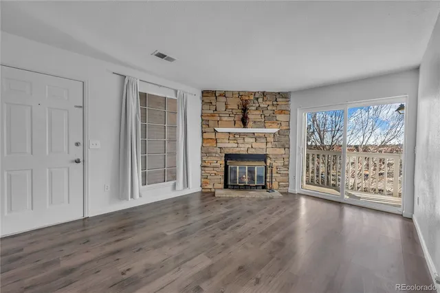 wooden floor fireplace and windows in an empty room