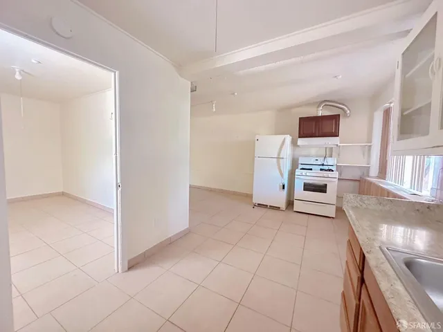 a view of kitchen with furniture and electronic appliances