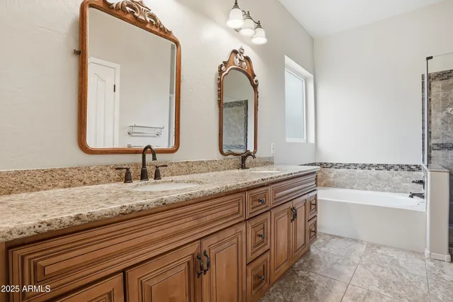 a bathroom with a granite countertop sink a mirror and a bathtub