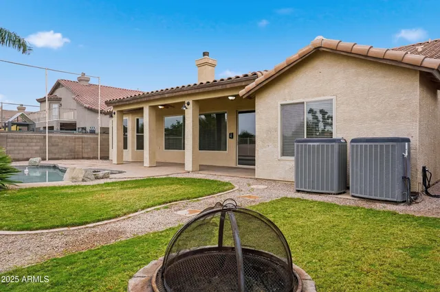 a view of a house with a yard patio and fire pit