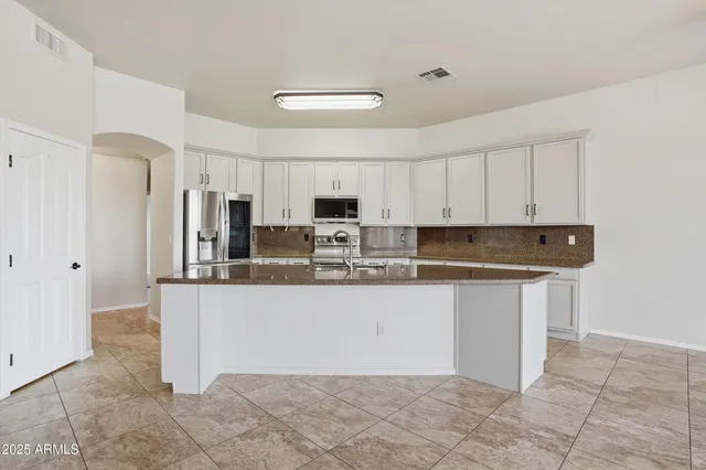 a kitchen with stainless steel appliances granite countertop a stove a sink a microwave and a refrigerator