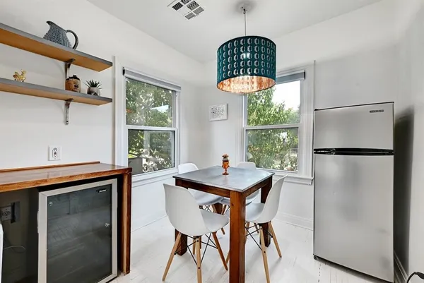 a table room with a window a dining table and a refrigerator