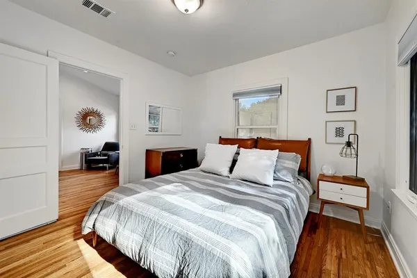 a bedroom with bed and wooden floor