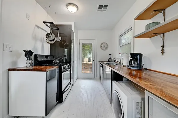 a kitchen with granite countertop a sink appliances cabinets and a counter top space