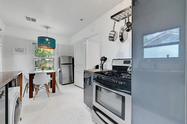 a kitchen with stainless steel appliances a stove a sink and a refrigerator