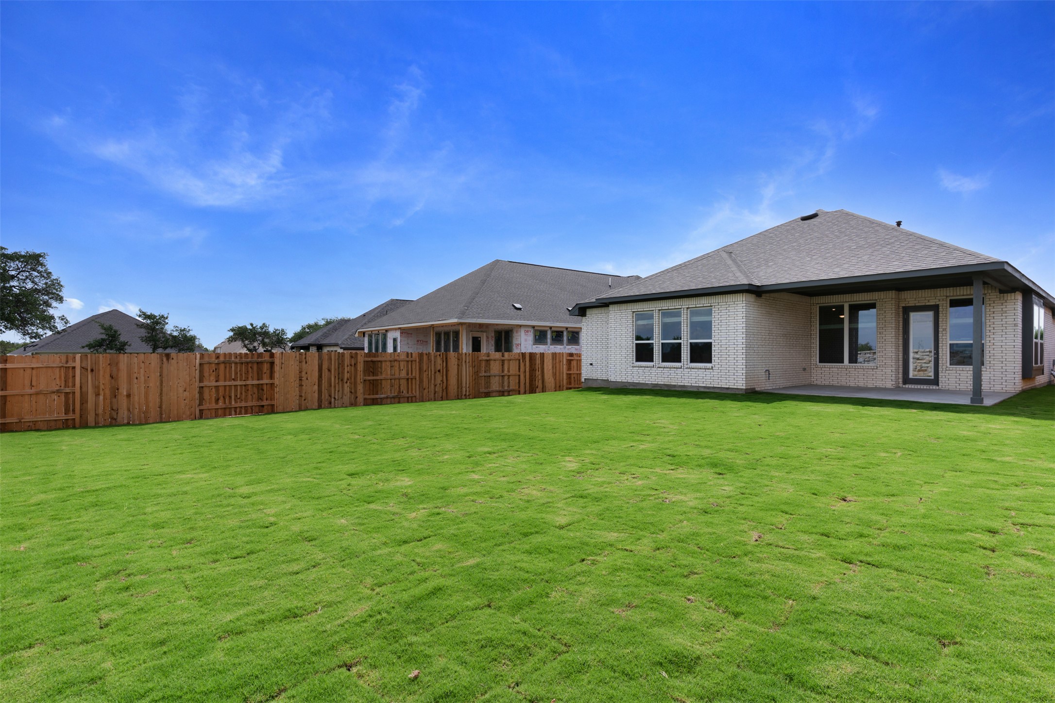 1129 Pansy Trail Georgetown, TX 78628 - Photo 21 of 29 Expansive backyard featuring a lush green lawn, full wood privacy fencing, and a covered concrete patio
