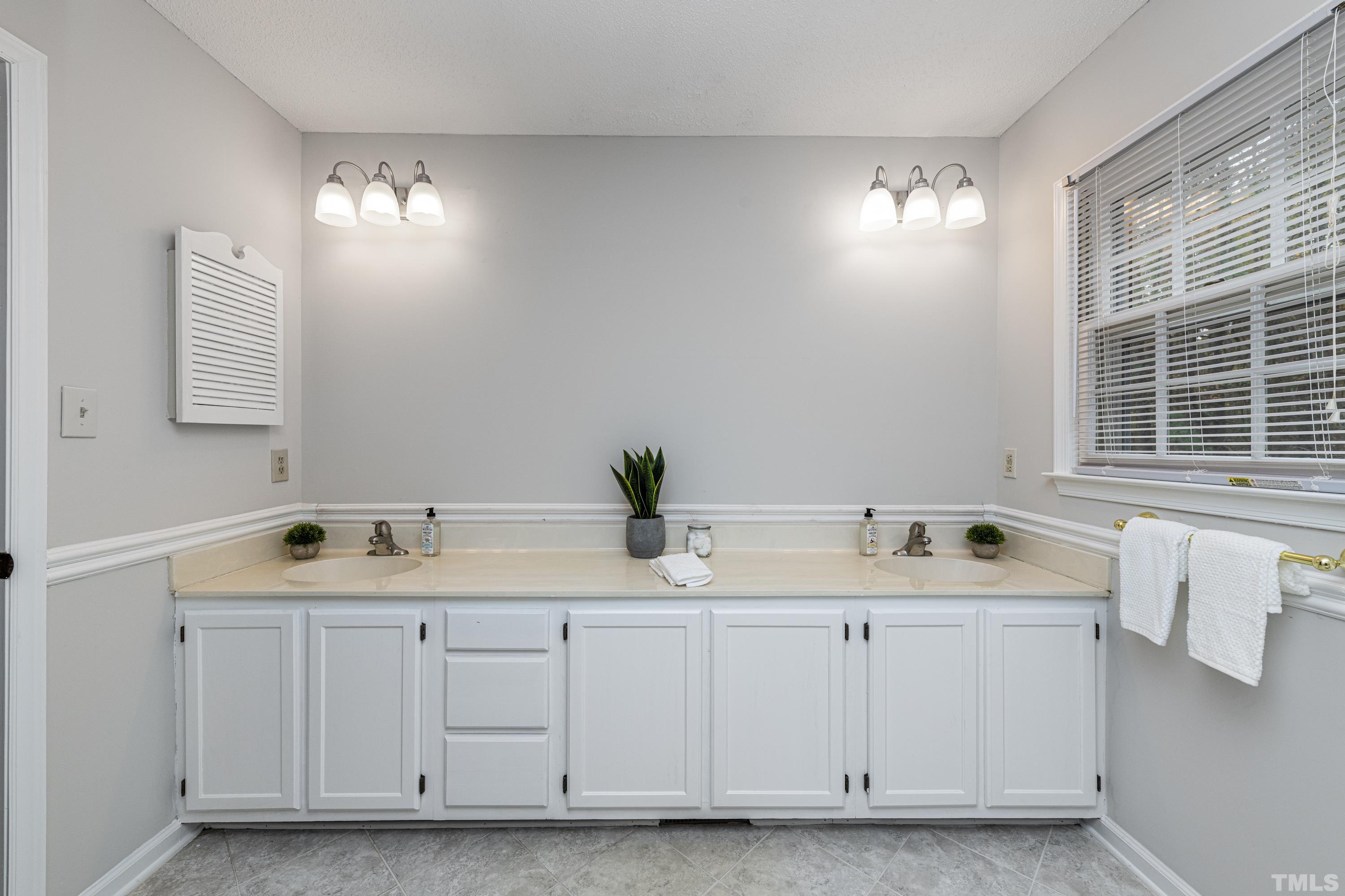 11913 North Exeter Way Raleigh, NC 27613 - Photo 21 of 29 a bathroom with double sink and a window