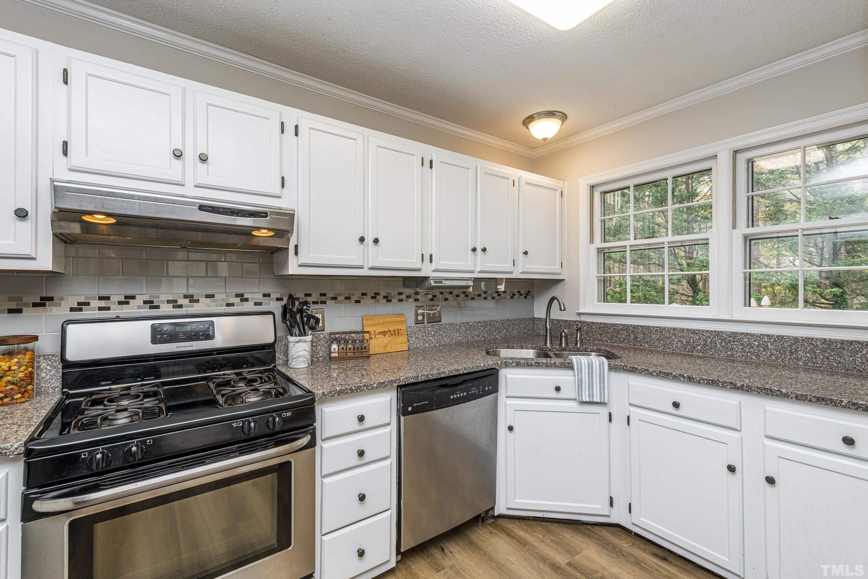 11913 North Exeter Way Raleigh, NC 27613 - Photo 5 of 29 a kitchen with granite countertop white cabinets and appliances