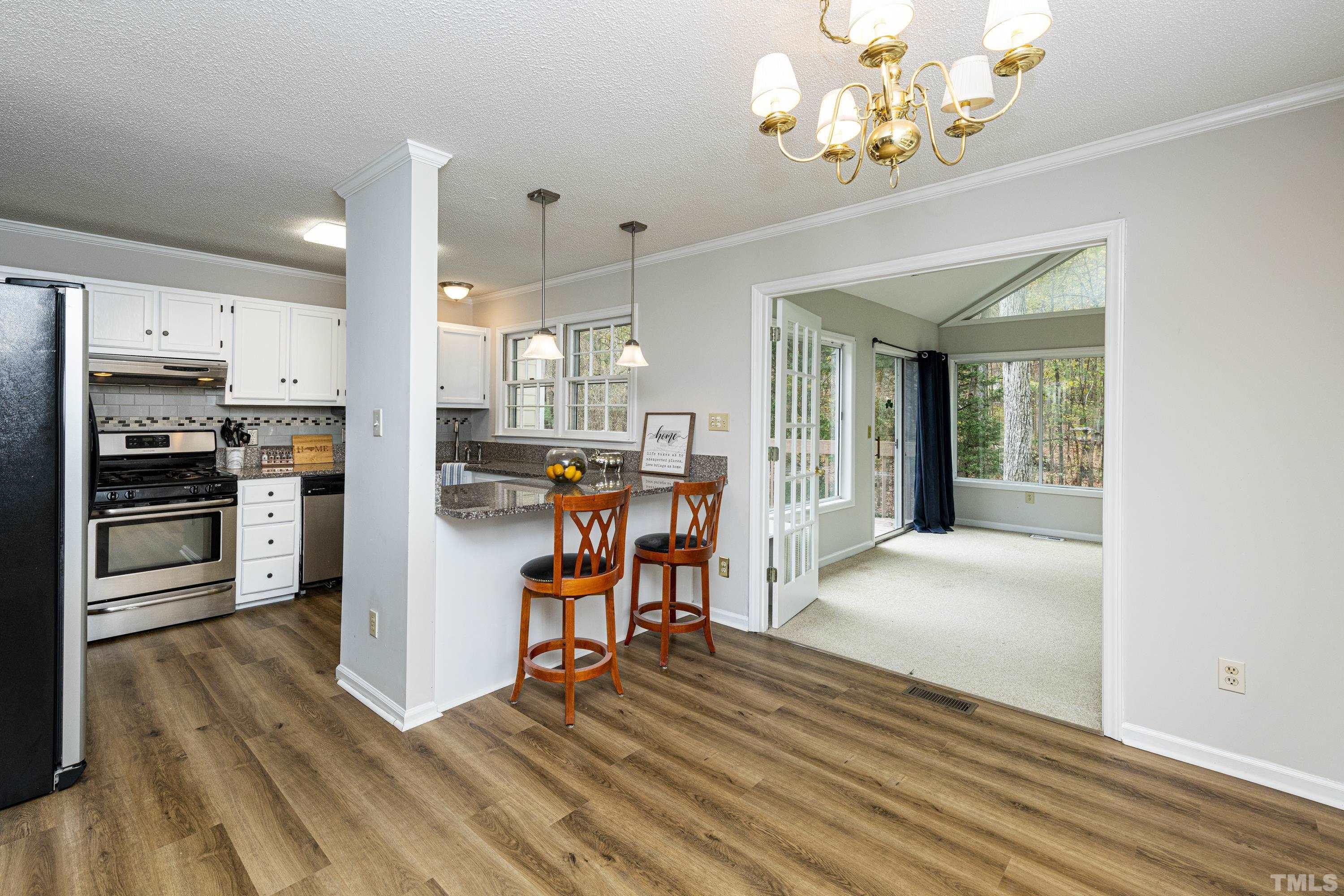11913 North Exeter Way Raleigh, NC 27613 - Photo 10 of 29 a view of a kitchen with a stove cabinets and wooden floor