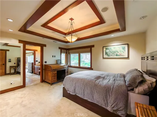 a bedroom with bed mirror and window