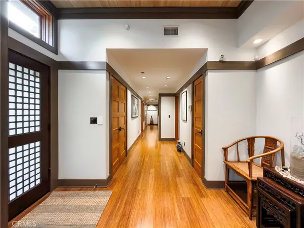 a view of a hallway with wooden floor and staircase