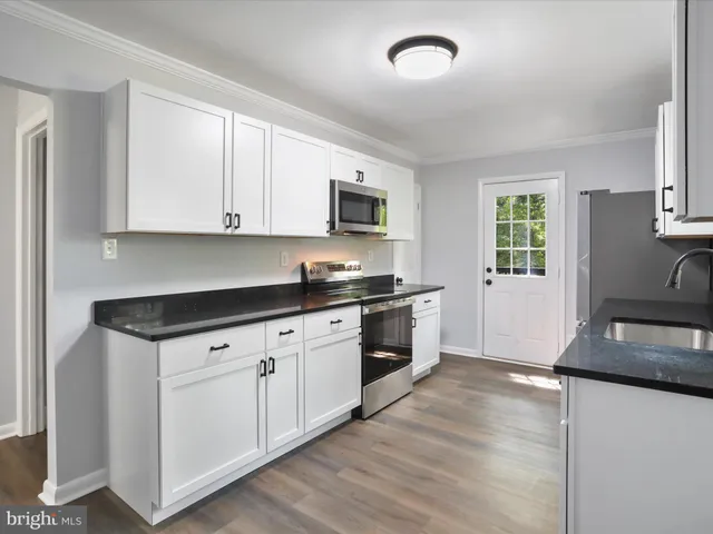 a kitchen with granite countertop a stove a sink and a granite counter tops