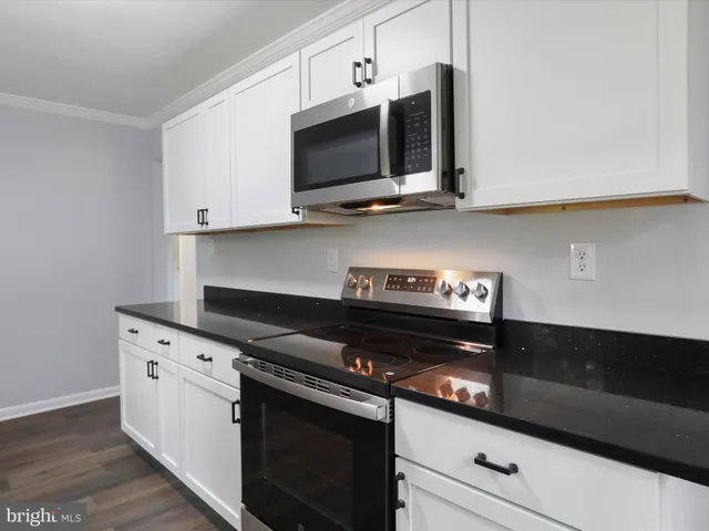 a kitchen with stainless steel appliances granite countertop a stove and a microwave