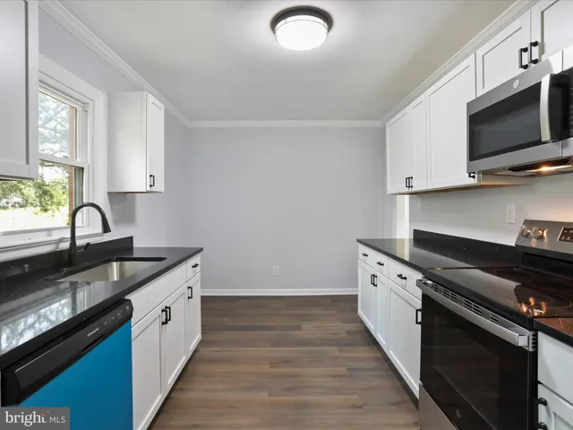 a kitchen with a sink stove and microwave