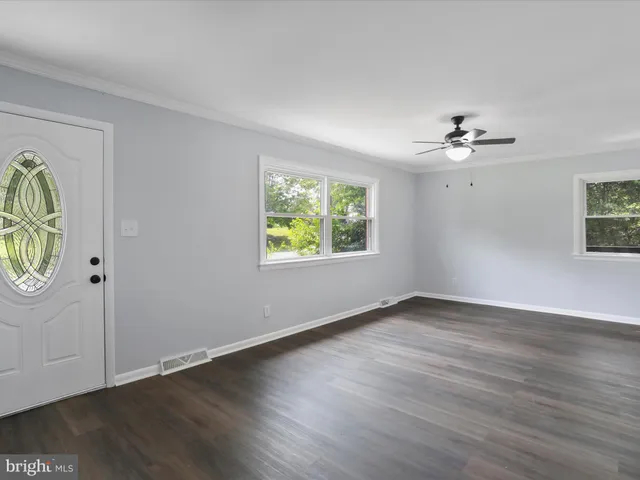 wooden floor in an empty room with a window