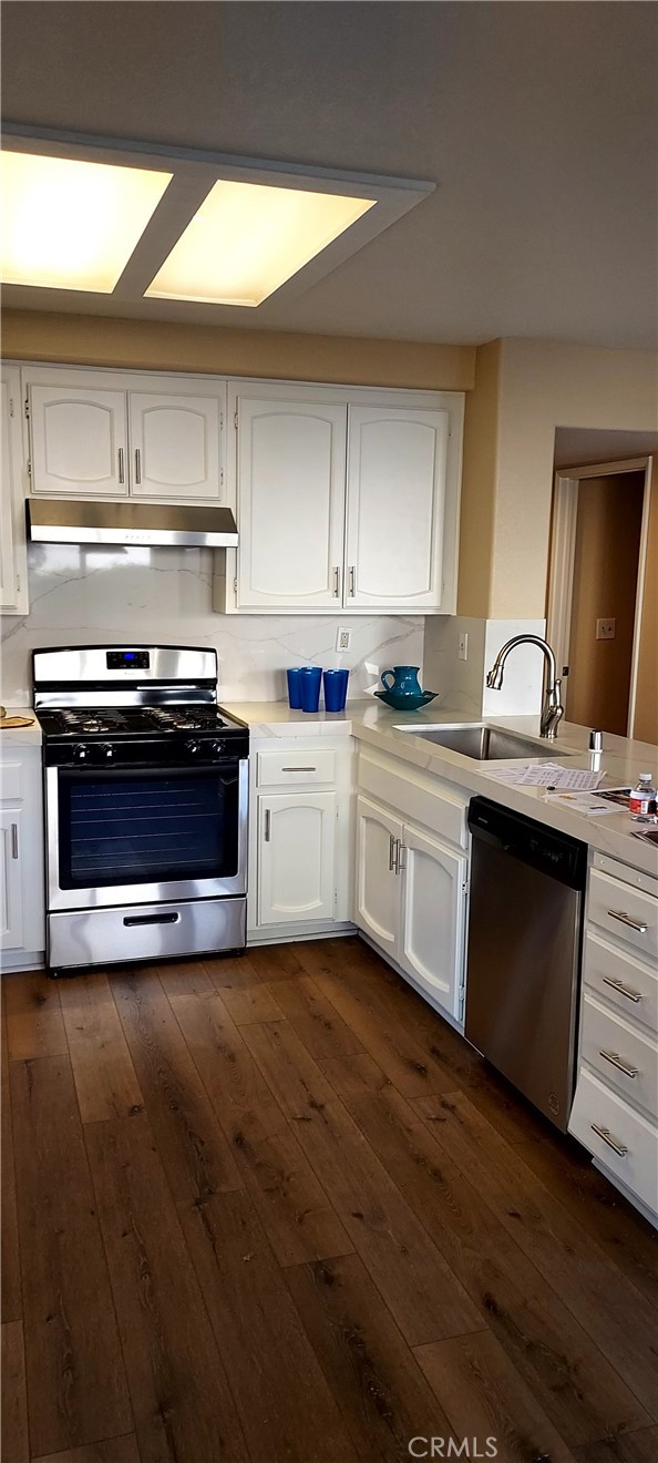 2186 Luz Way Oceanside, CA 92056 - Photo 12 of 24 a kitchen with stainless steel appliances a sink a stove a microwave a sink and wooden cabinets