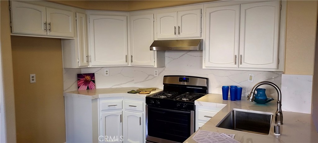 2186 Luz Way Oceanside, CA 92056 - Photo 14 of 24 a kitchen with stainless steel appliances granite countertop a stove a sink dishwasher and cabinets with wooden floor