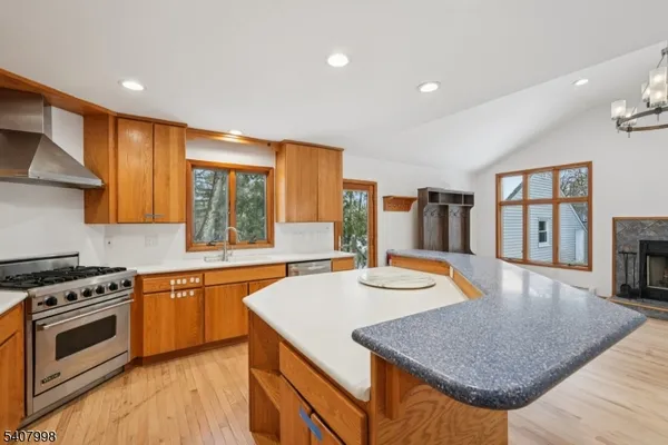 a kitchen with stainless steel appliances granite countertop a stove a sink and a refrigerator
