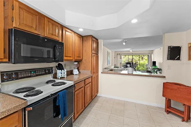 a kitchen with stainless steel appliances granite countertop a stove top oven microwave and refrigerator