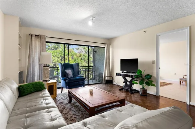 a living room with furniture a flat screen tv and a large window