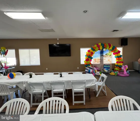 a view of backyard with swimming pool and seating space