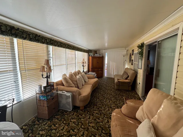 a living room with furniture wooden floor and a large window