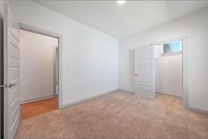 10805 Meris Lane Austin, TX 78754 - Photo 15 of 28 A spacious bedroom offers a neutral canvas, ready for personalized touches, complete with plush carpeting and a walk-in closet.