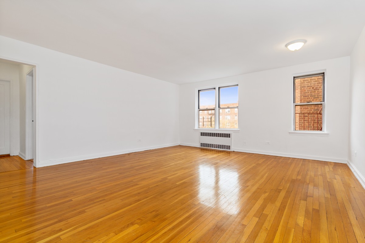 67-07 Yellowstone Boulevard, Unit 5G Queens, NY 11375 - Photo 4 of 7 a view of empty room with wooden floor and fan
