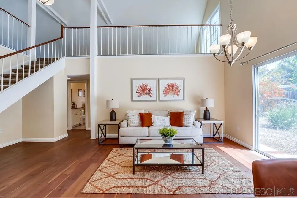 7214 Durango Circle Carlsbad, CA 92011 - Photo 16 of 37 a dining room with wooden floor and a chandelier