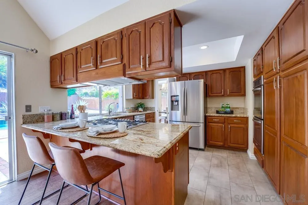 7214 Durango Circle Carlsbad, CA 92011 - Photo 20 of 37 a kitchen with stainless steel appliances granite countertop a kitchen island hardwood floor sink and stove
