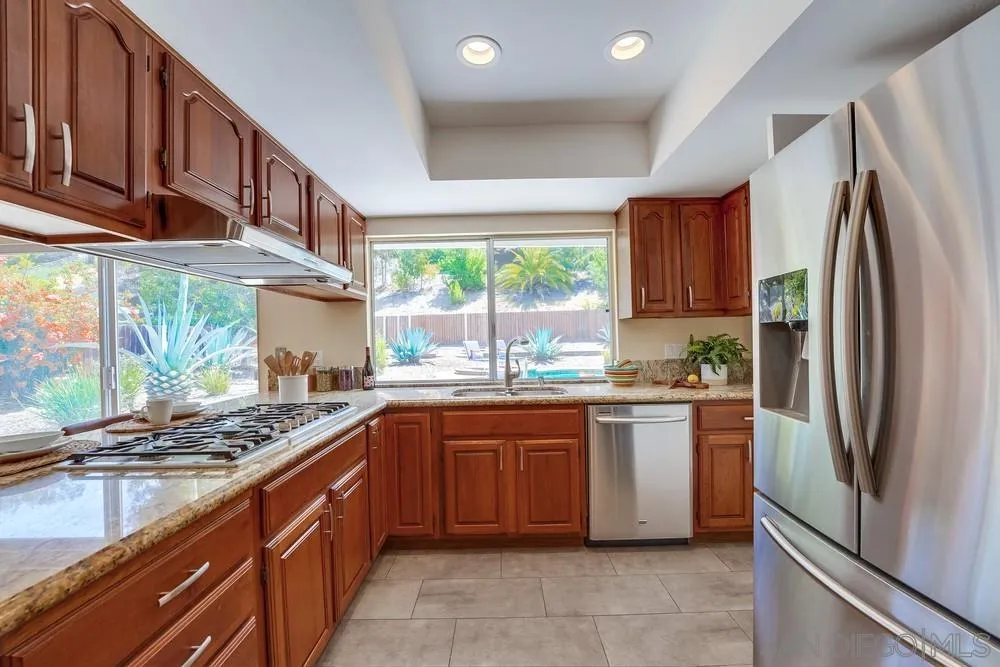 7214 Durango Circle Carlsbad, CA 92011 - Photo 21 of 37 a kitchen with stainless steel appliances granite countertop a refrigerator and a sink