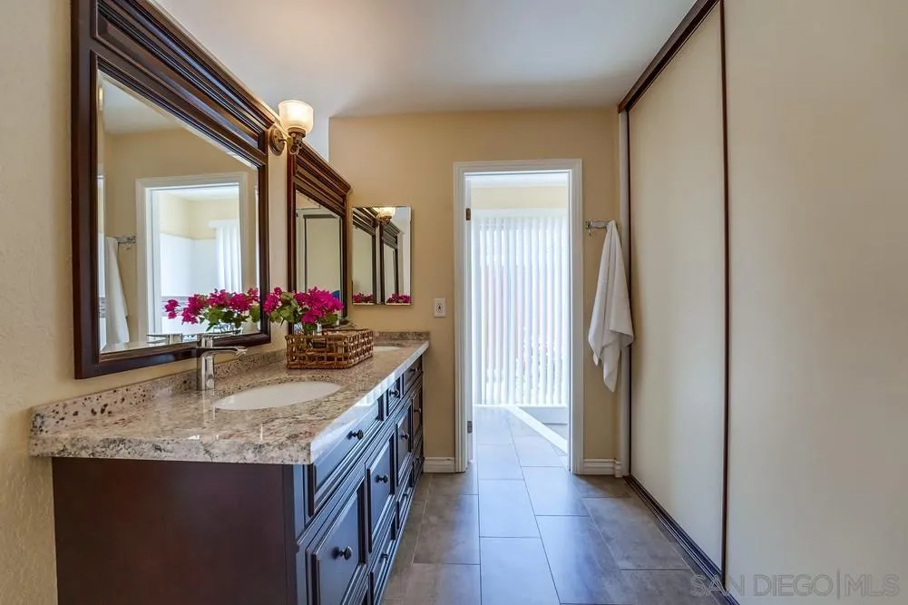 7214 Durango Circle Carlsbad, CA 92011 - Photo 30 of 37 a bathroom with a granite countertop sink and a mirror