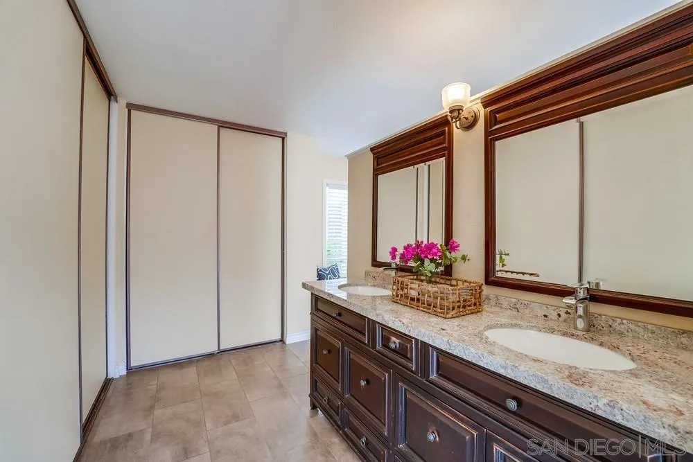 7214 Durango Circle Carlsbad, CA 92011 - Photo 31 of 37 a bathroom with a granite countertop sink and a mirror