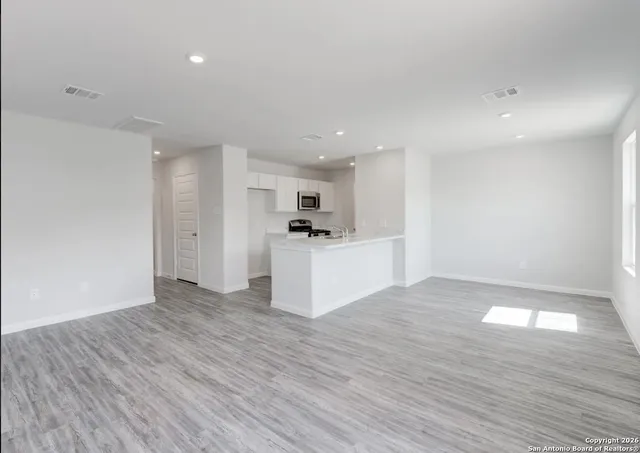 a view of a kitchen with wooden floor and a sink