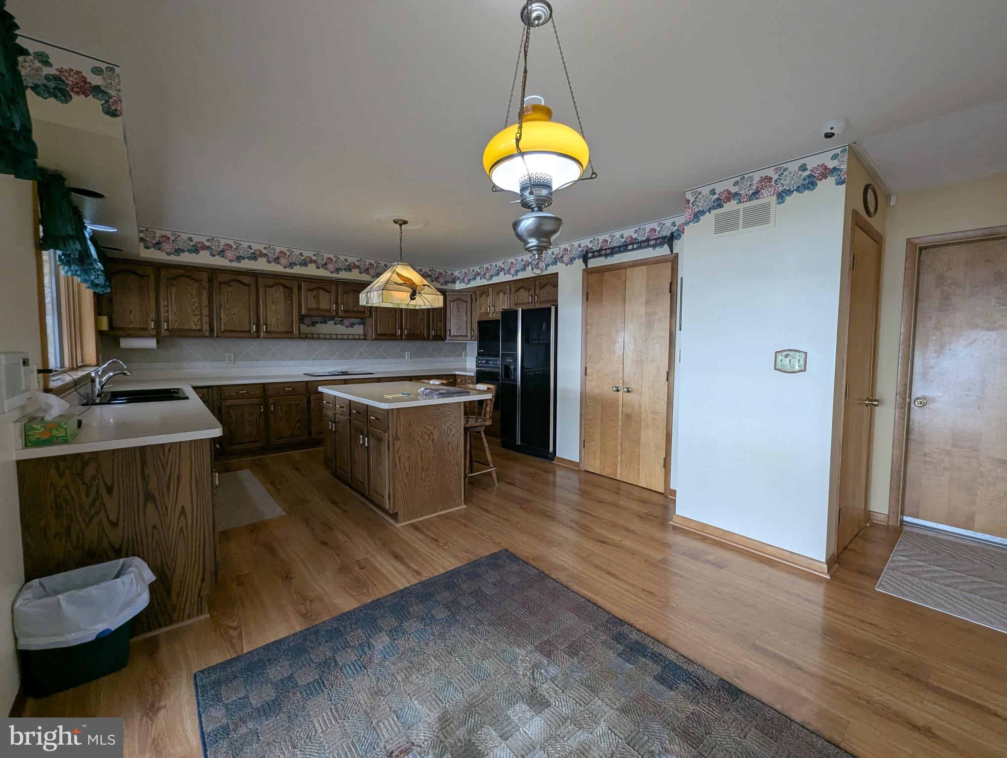 3729 Abingdon Beach Road Abingdon, MD 21009 - Photo 58 of 85 a kitchen with stainless steel appliances granite countertop a sink dishwasher and a fireplace with wooden floor