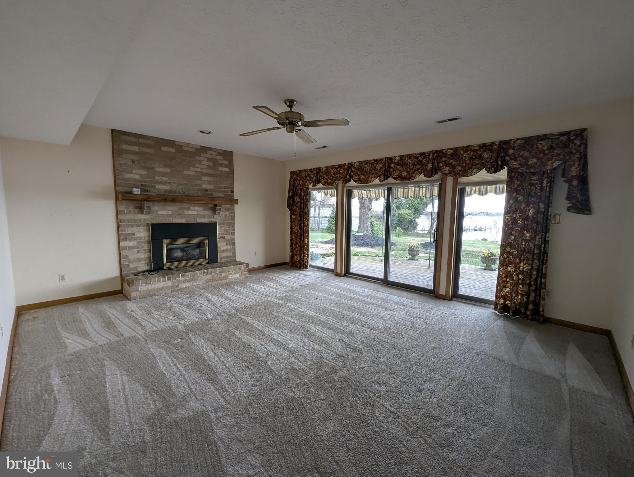 3729 Abingdon Beach Road Abingdon, MD 21009 - Photo 72 of 85 a view of an empty room with a fireplace and a window