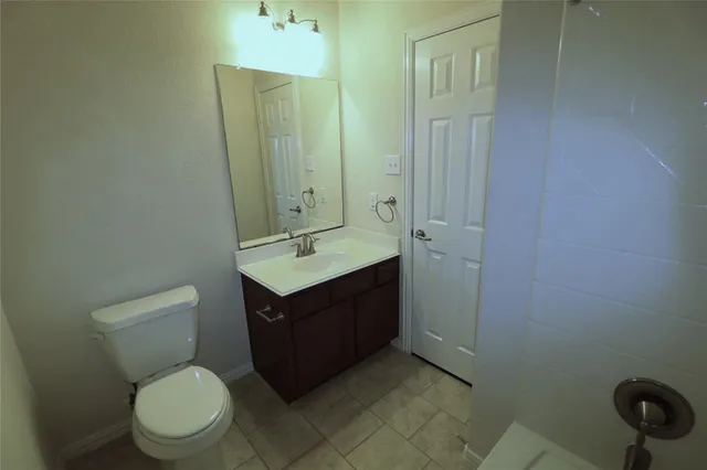 a bathroom with a toilet a sink and mirror