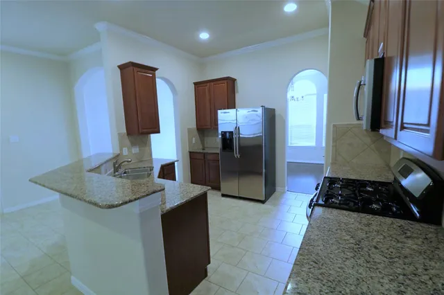 a kitchen with stainless steel appliances granite countertop a refrigerator and a stove