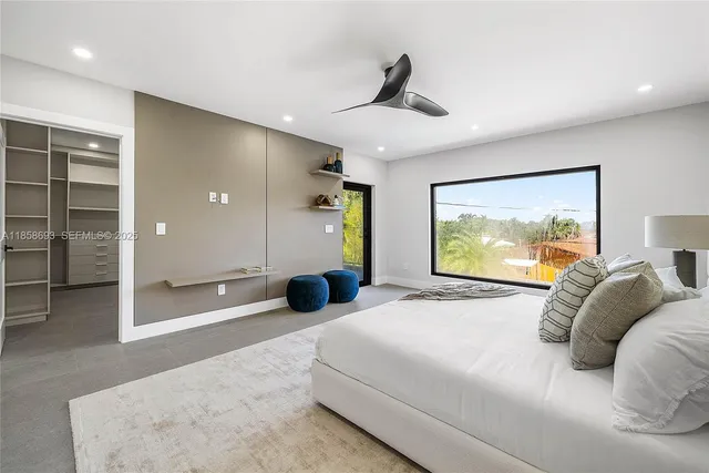 a large bedroom with bed tv and window
