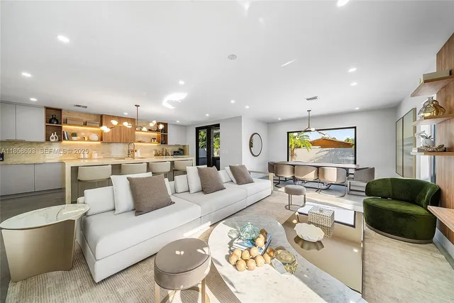 a large kitchen with kitchen island a sink a counter top space and living room view