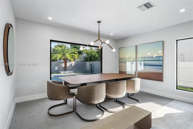 a dining room with furniture and a potted plant