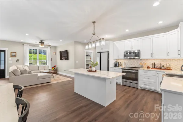a kitchen with kitchen island granite countertop a sink cabinets and wooden floor