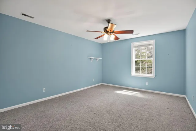 a view of a livingroom with a ceiling fan and window