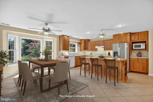 a dining area with stainless steel appliances kitchen island granite countertop a dining table and chairs
