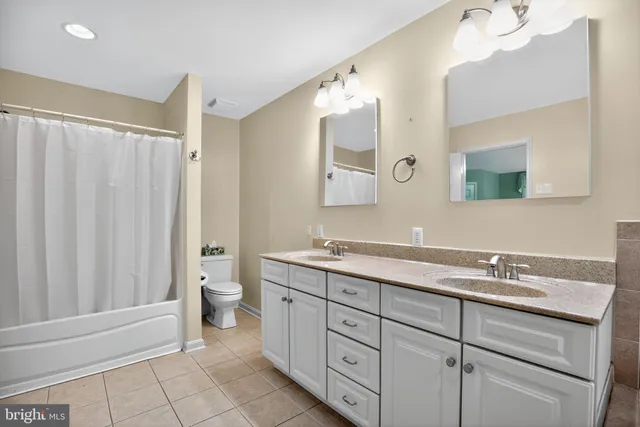 a spacious bathroom with a double vanity sink a mirror and a